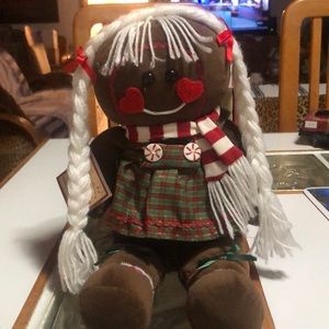 Gingerbread doll decoration. She is wearing a red and a white stripe scarf.